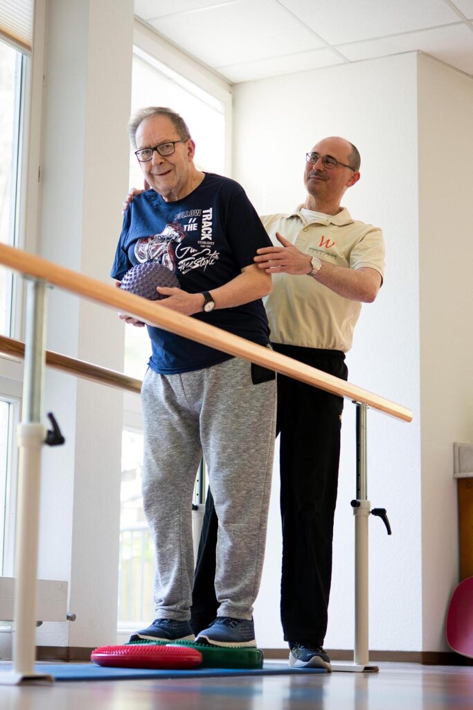 Physiotherapeutin führt mit Patientin gezielte Bewegungs- und Kräftigungsübungen durch